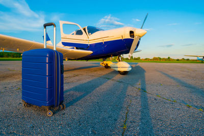 Airplane on airport runway against sky