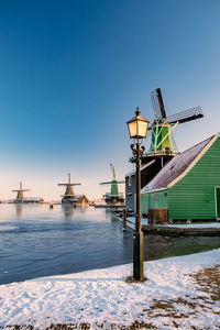 Crane by building against clear sky during winter