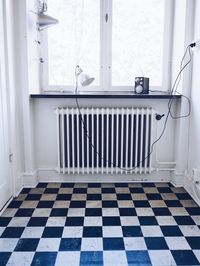 Radiator on wall below window at home