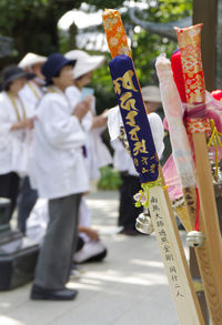 Close-up of religious sticks while people in background