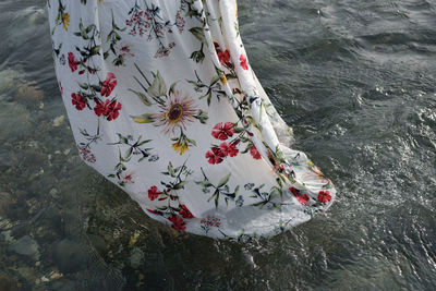 Low section of woman standing by sea