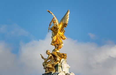 Low angle view of angel statue against sky