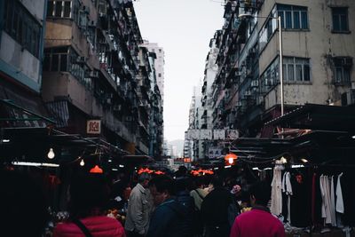 People on street in city against sky