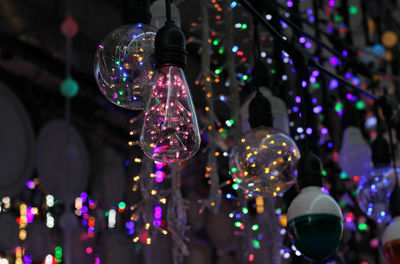 Low angle view of illuminated lighting equipment hanging on ceiling