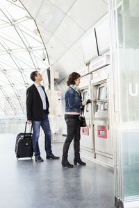 Business people buying tickets at railroad station