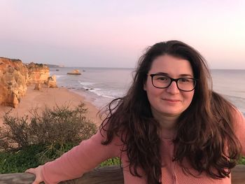 Portrait of young woman at beach during sunset