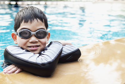 Asian happy kid playing slider in swimming pool