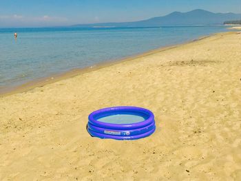 Deck chairs on beach against blue sky