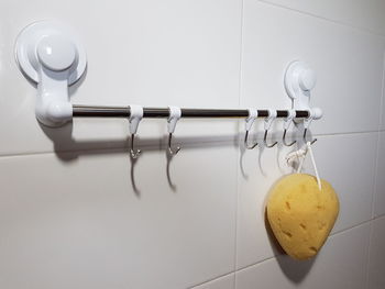Close-up of cleaning sponge hanging on hook in bathroom