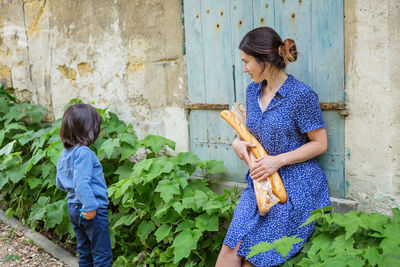 Young woman sitting with french baguettes in the countryside