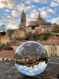 Close-up of crystal ball on building against sky