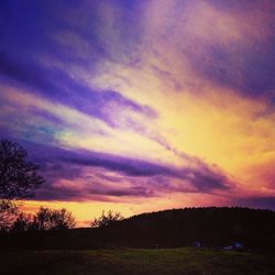 Silhouette landscape against dramatic sky during sunset