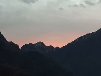 Scenic view of silhouette mountains against sky at sunset