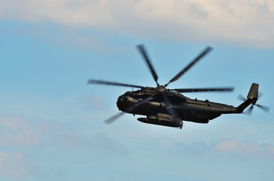 Low angle view of helicopter flying against sky