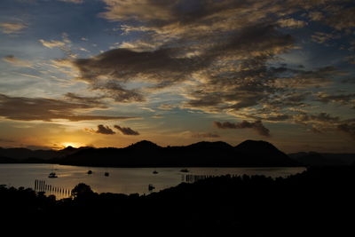 Scenic view of dramatic sky over silhouette mountain