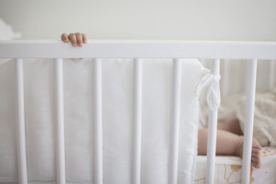 Low section of baby in crib at home