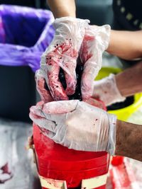 Cropped hands wearing gloves while working