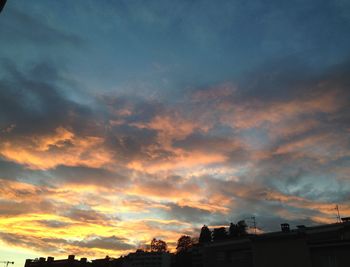 Buildings against cloudy sky at sunset