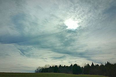 Scenic view of grassy field against cloudy sky