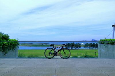 Bicycle by railing against sky