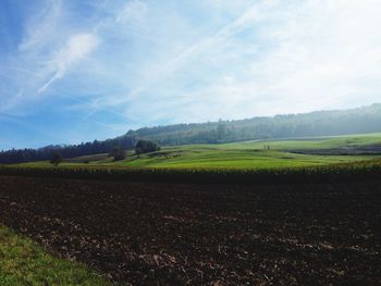 Scenic view of field against cloudy sky