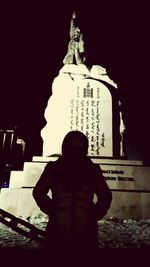 Rear view of statue against clear sky at night