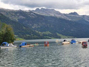 Boats in lake against mountains