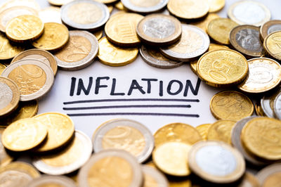 Word inflation, surrounded by euro coins. rising prices, inflation,  economic repercussions.