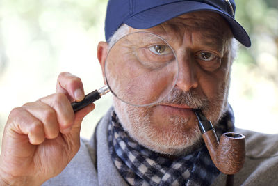 Close-up portrait of man holding camera