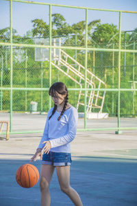 Woman playing basketball at court