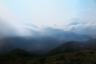 Scenic view of mountains against cloudy sky