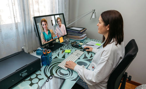 Doctor video conferencing witth collegues over computer