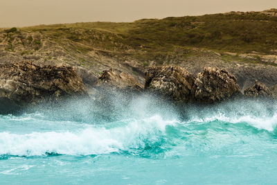 Waves crashing on the rocks of a beach in cantabria, spain. horizontal image.