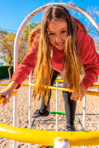 Portrait of young woman sitting on railing