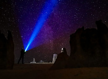 Low angle view of silhouette people against sky at night