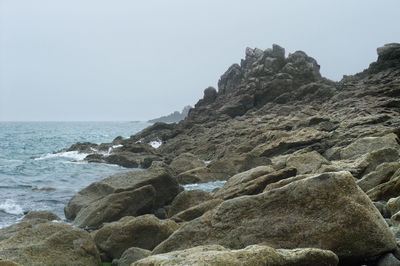 Rock formation on beach against clear sky