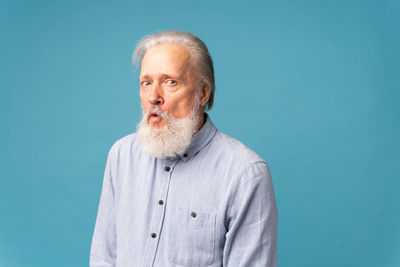 Portrait of young man against blue background