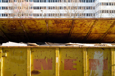 Dirty recycling bin against building in city