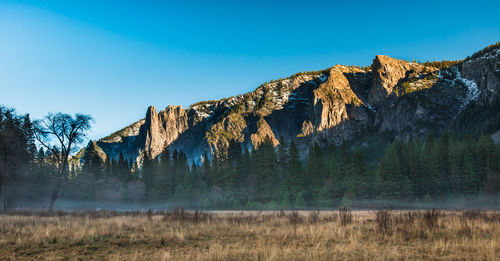 Scenic view of rocky mountains against clear blue sky