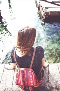 Rear view of woman sitting in water