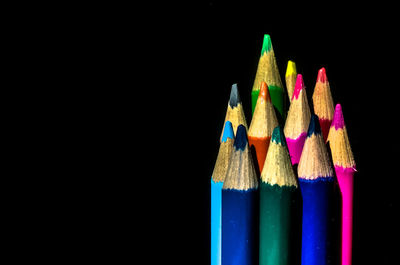 Close-up of multi colored pencils against black background