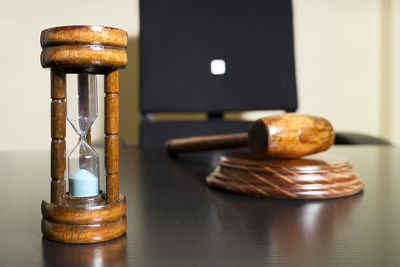 High angle view of gavel with hourglass on wooden table