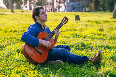 Man playing guitar on field