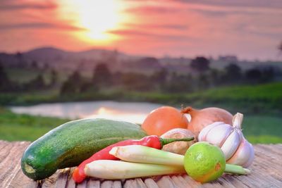 Close-up of oranges on table against sky during sunset