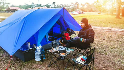 Man sitting on chair at campsite