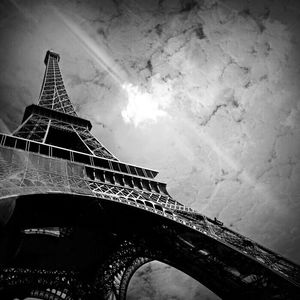 Low angle view of eiffel tower against cloudy sky