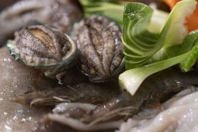 Raw abalones in the seafood stew before boiling