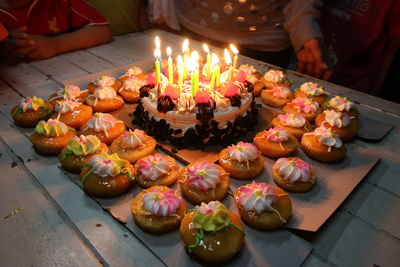 Midsection of people by birthday cake