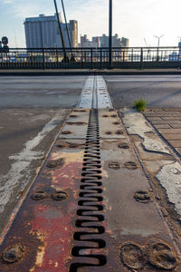 Surface level of railroad tracks in city against sky