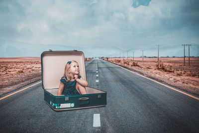 Portrait of happy girl on road against sky